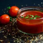 A side-by-side comparison of marinara and tomato sauce in two bowls, highlighting their distinct textures and ingredients.