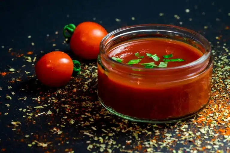 A side-by-side comparison of marinara and tomato sauce in two bowls, highlighting their distinct textures and ingredients.