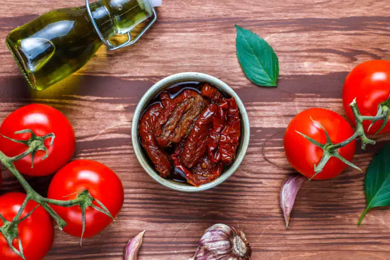 A bowl of authentic marinara sauce beside a tube of tomato paste, highlighting the differences in ingredients and texture.