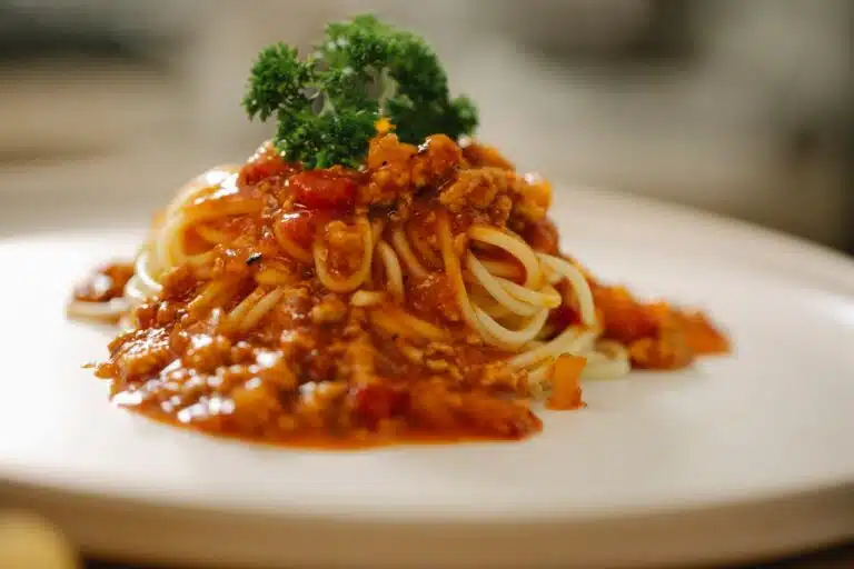 A bowl of spaghetti with rich sauce and flavorful add-ins, ready to enhance your meal