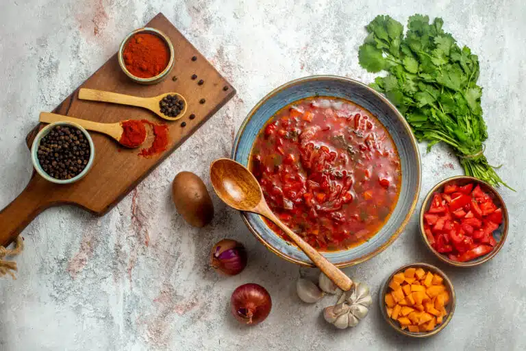 A bowl of pasta topped with the perfect liquid marinara sauce, garnished with basil leaves.