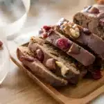 Sliced almond nut cake on a plate, showcasing the rich texture and almond topping