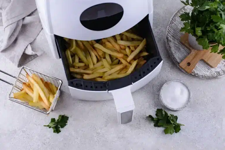 Frozen fries being air fried in a basket