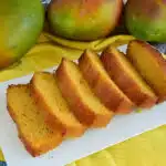 Freshly baked mango bread on a cooling rack, with vibrant mango pieces visible, ready to be enjoyed.