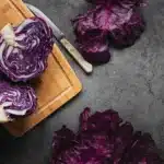 A vibrant dish of roasted purple cauliflower garnished with fresh herbs